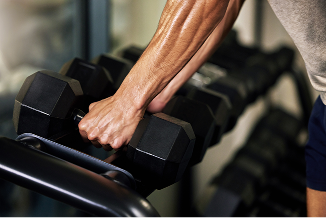 Member selecting a dumbbell from a weight rack